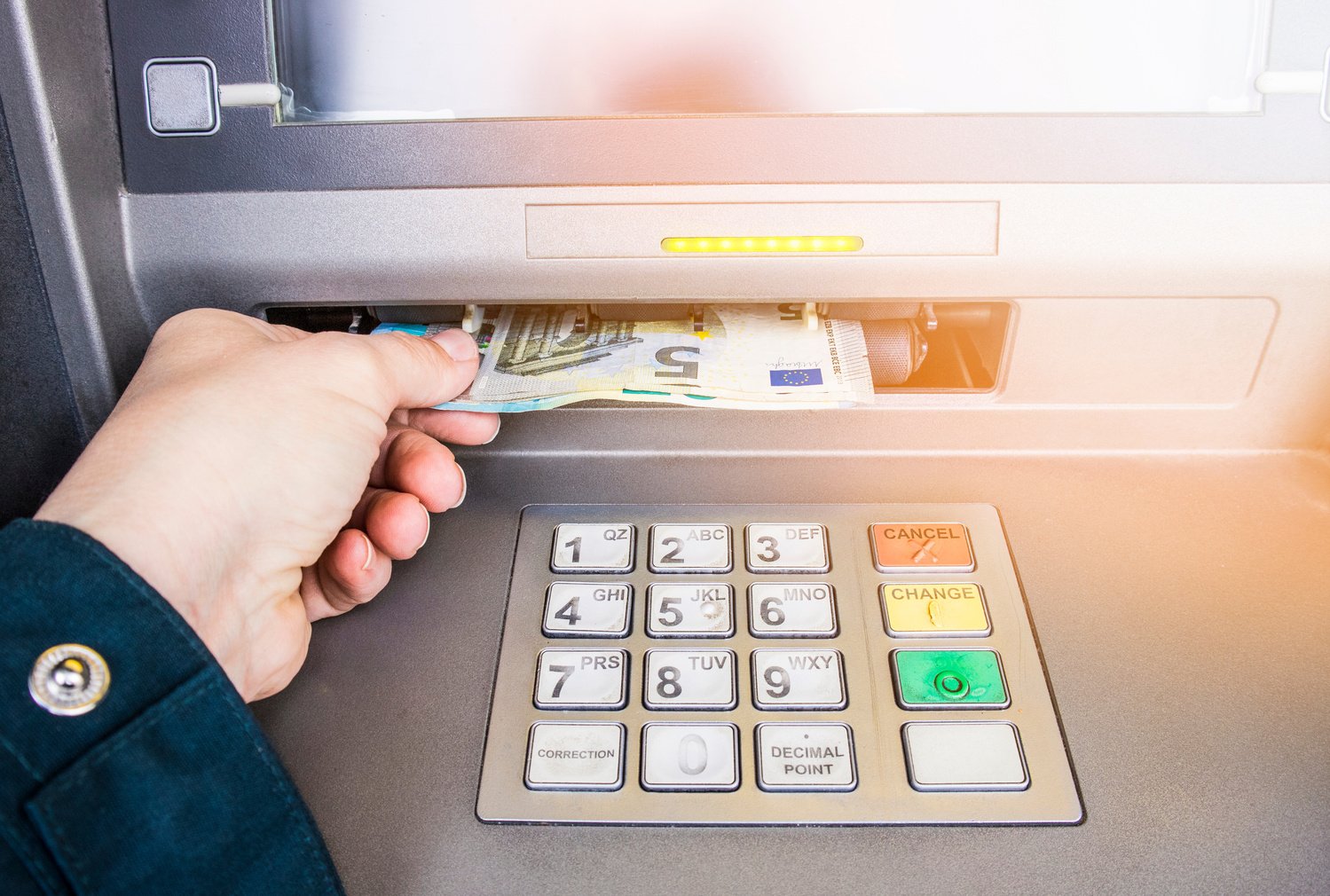 Happy person taking euro money from ATM bank machine.